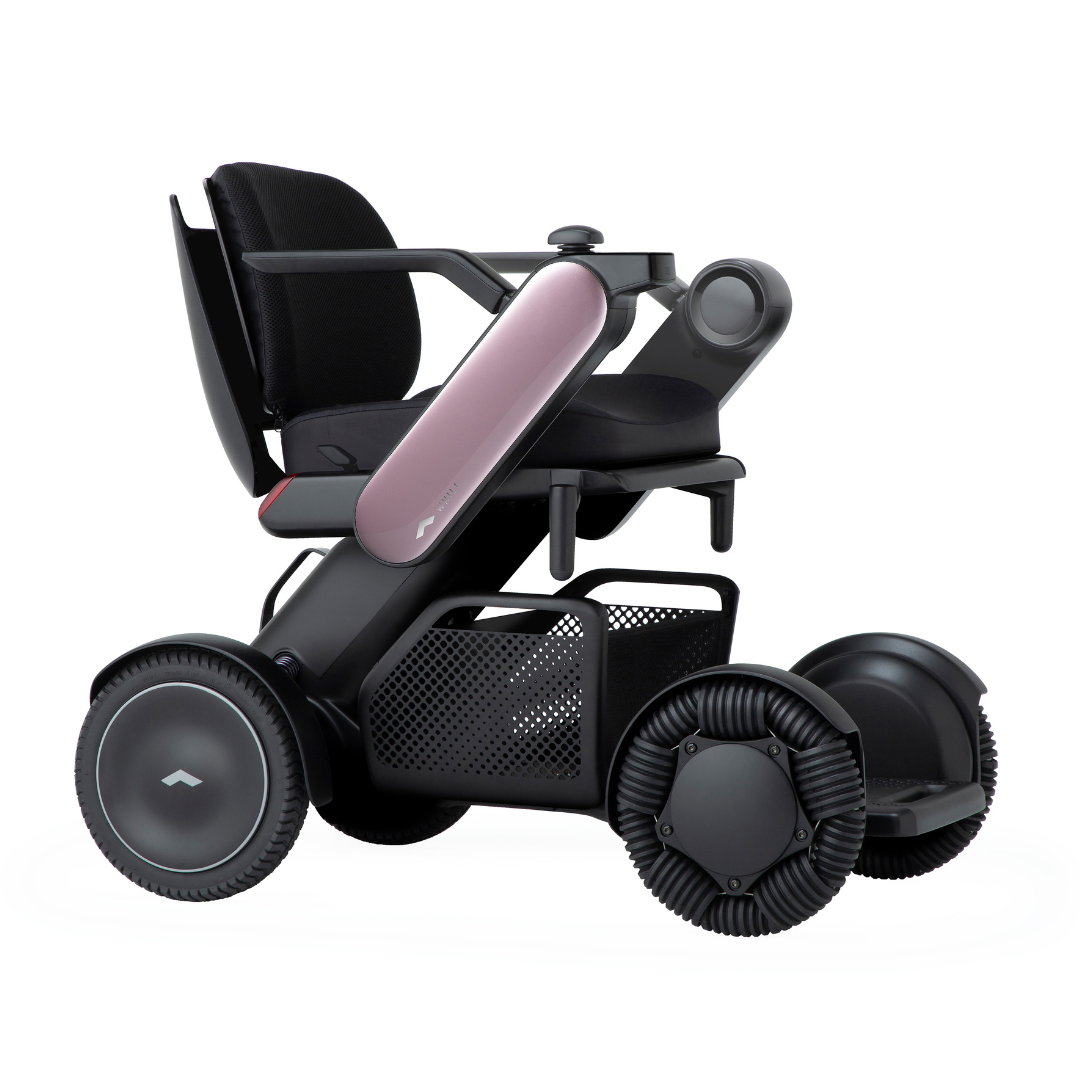 The Whill Model C2 Smart Power Chair - Compact Portable Mobility is a sleek black and pink motorized wheelchair with large wheels, armrests, mesh basket, ergonomic backrest, and FDA-compliant Class II medical device design for enhanced mobility.